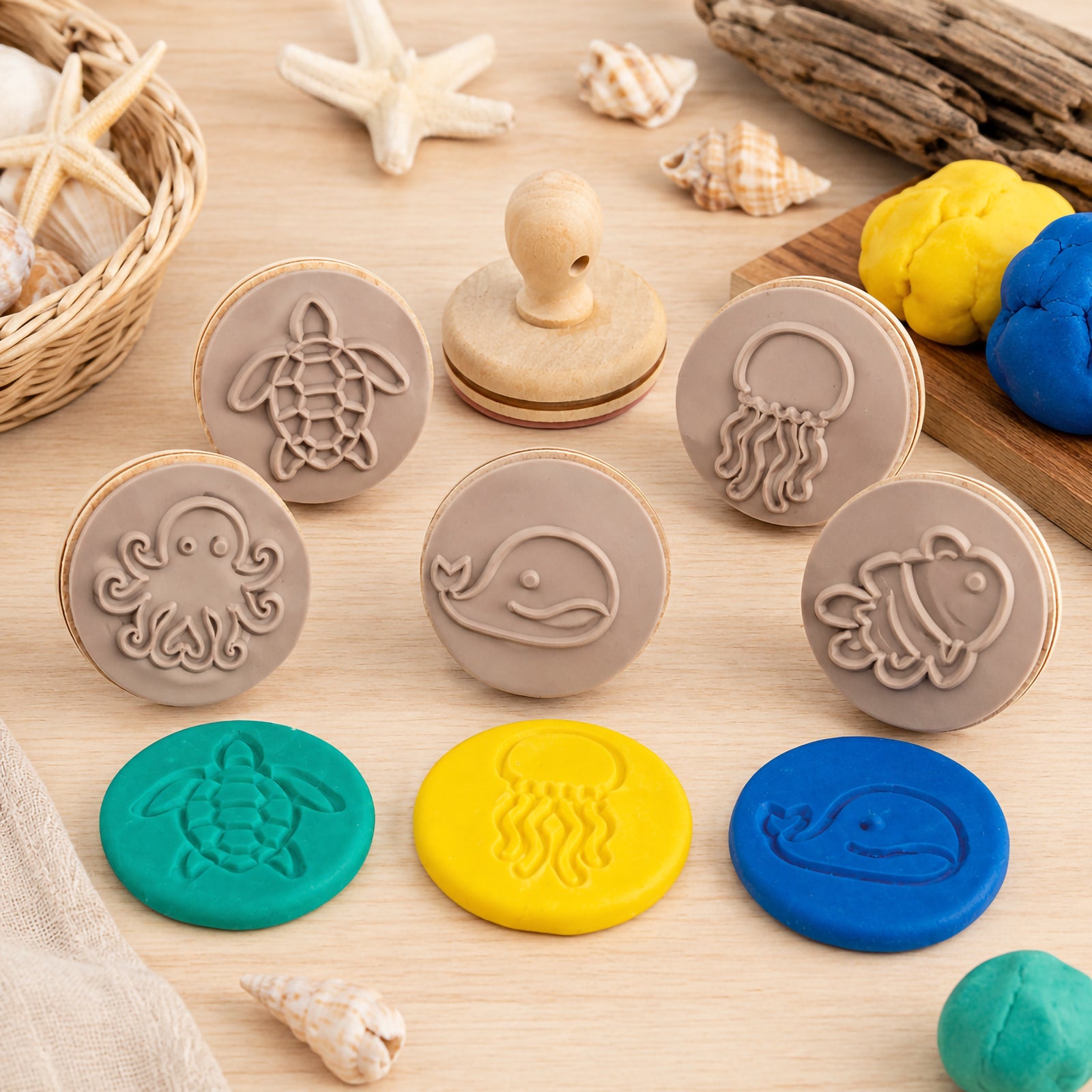 Educational Colours Wooden Dough Stamps Sea Creatures set displayed on a wooden surface with colourful dough impressions and ocean themed decorations. The image features sea creature stamp designs including turtle, jellyfish, octopus, whale and fish for sensory learning and creative play activities.