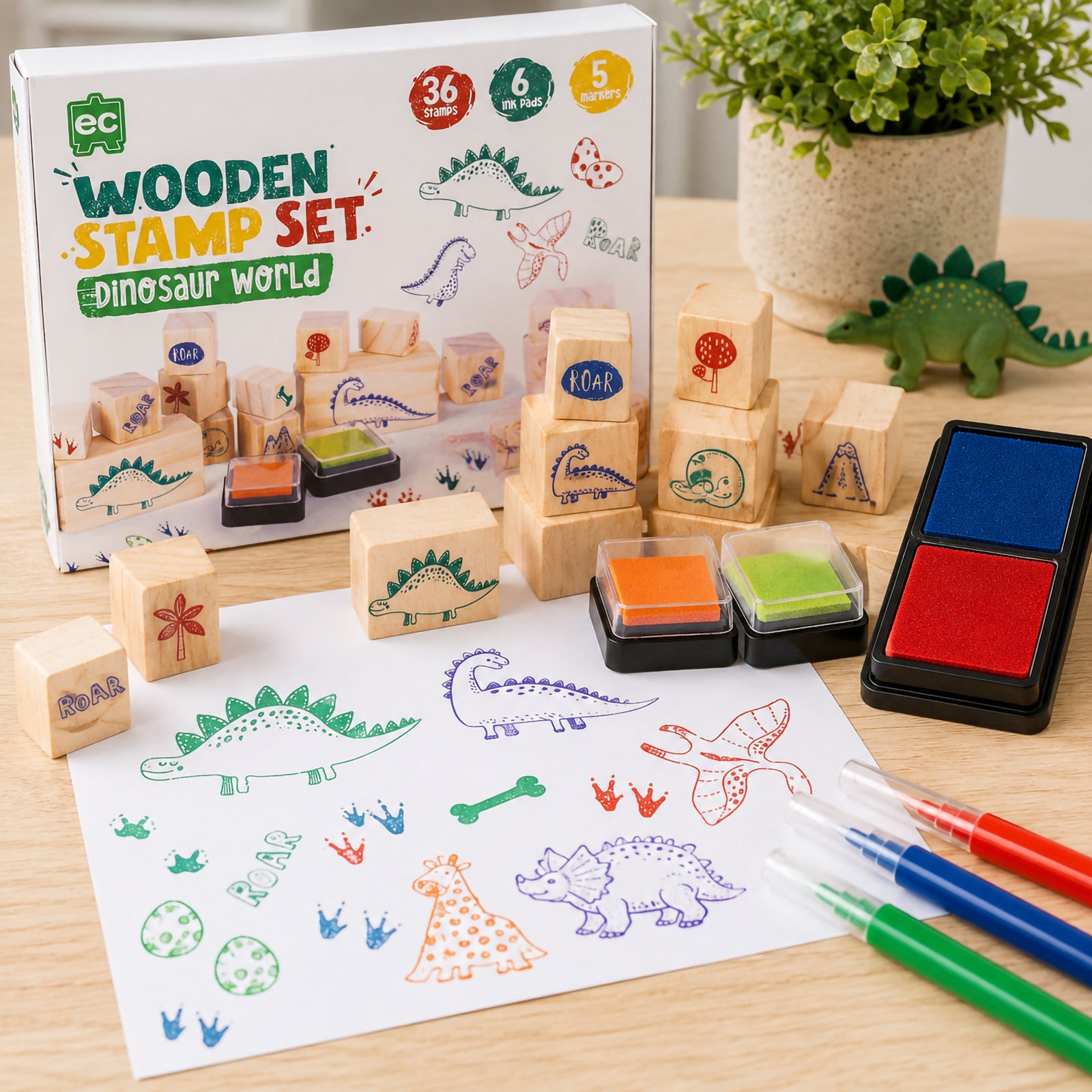 Educational Colours Wooden Stamp Set Dinosaurs displayed with retail packaging, wooden dinosaur stamps, colourful ink pads, and completed prehistoric stamp artwork on white paper.