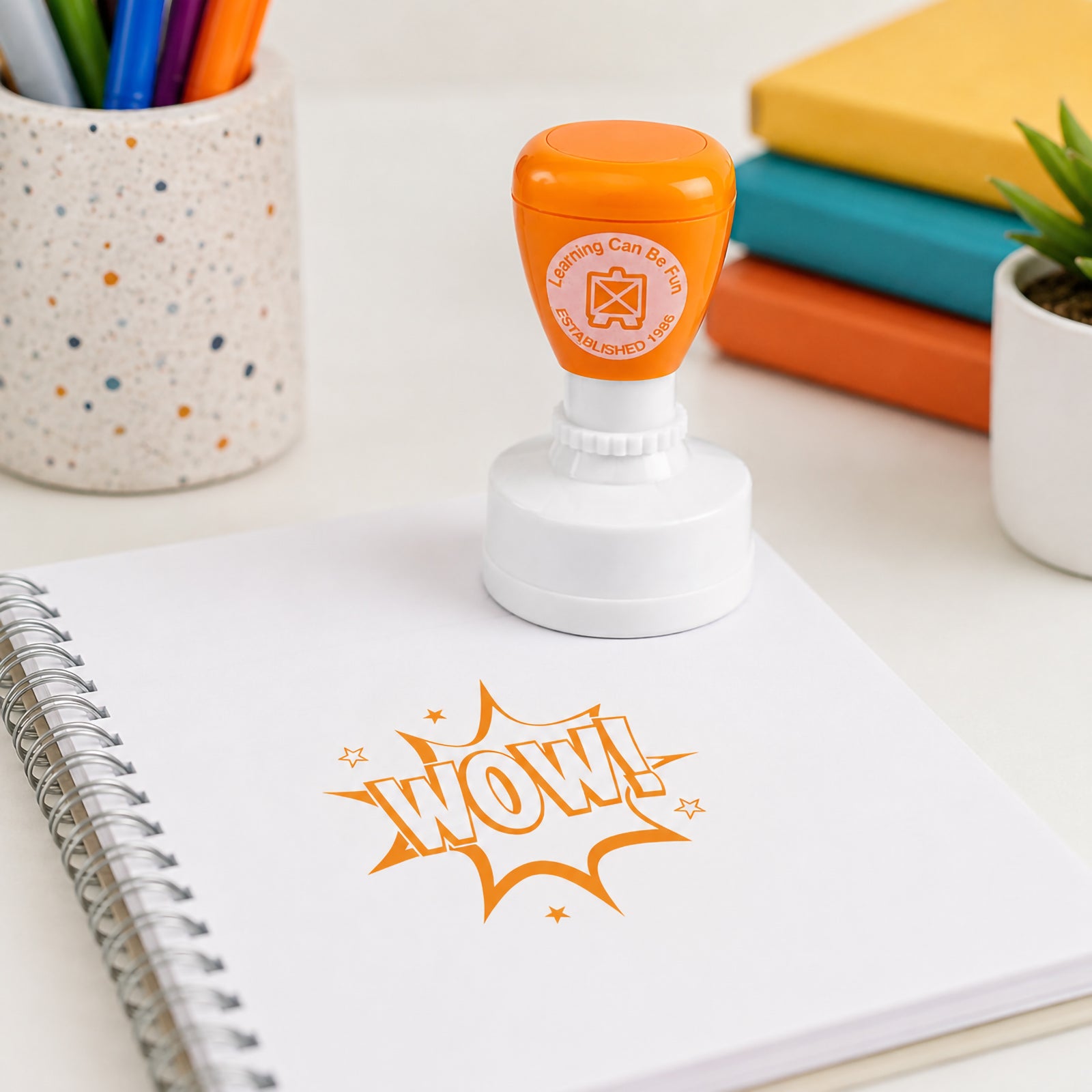 Wow Merit Stamp positioned on a spiral notebook with a large and vibrant WOW! impression. The image demonstrates how teachers can provide clear, engaging feedback that motivates students and celebrates learning success.