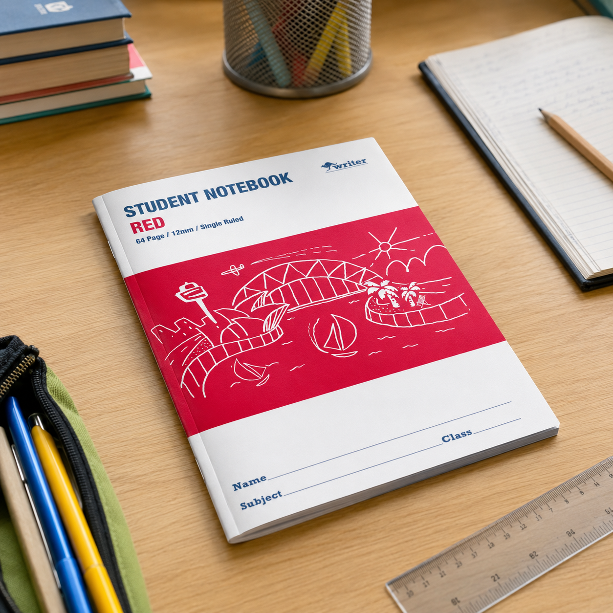 Red student notebook on a wooden desk with stationery items