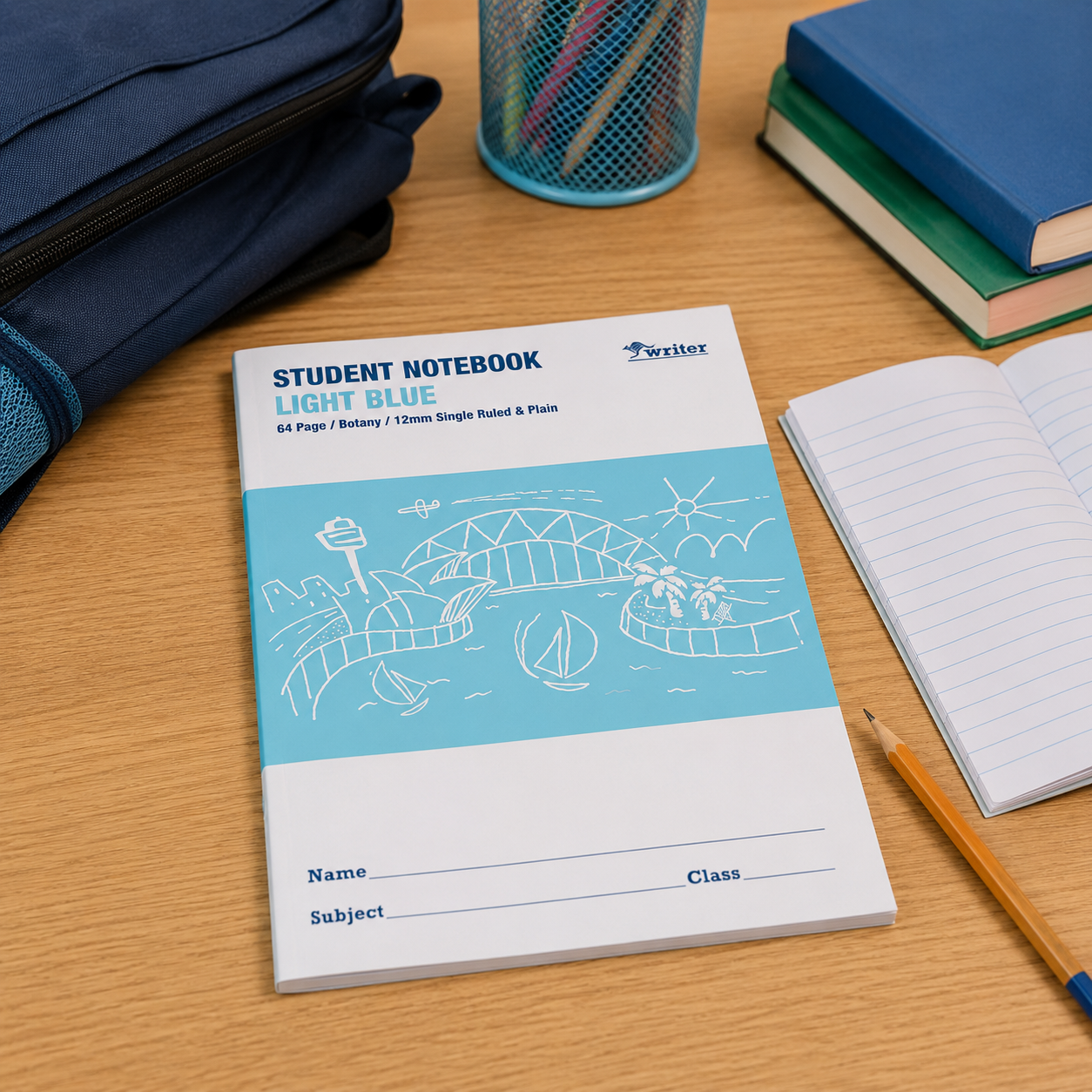 Writer WB91500 light blue student notebook placed on a wooden study desk with pencils, books, an open notebook and school supplies.