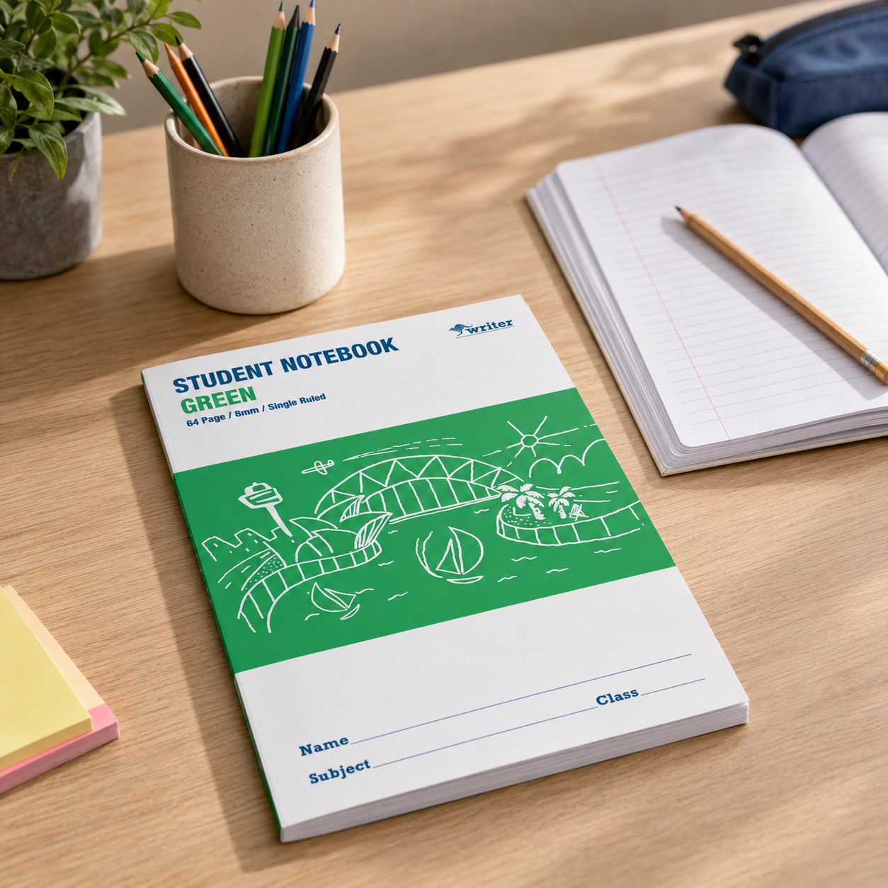 Student notebook with green cover on a wooden table with stationery items.