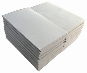 Two stacks of plain white Writer 5 x 3 inch office pads without wrappers, photographed from above at an angle