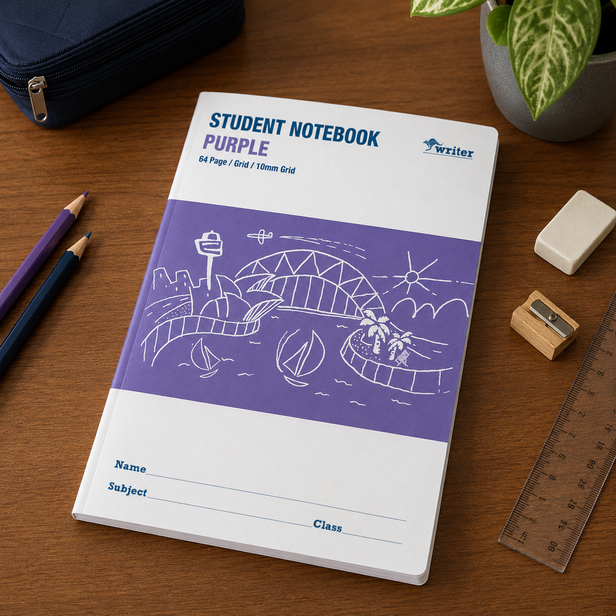 Desk scene, likely computer generated, of the purple Writer grid notebook beside pencils, an eraser, a sharpener and a ruler