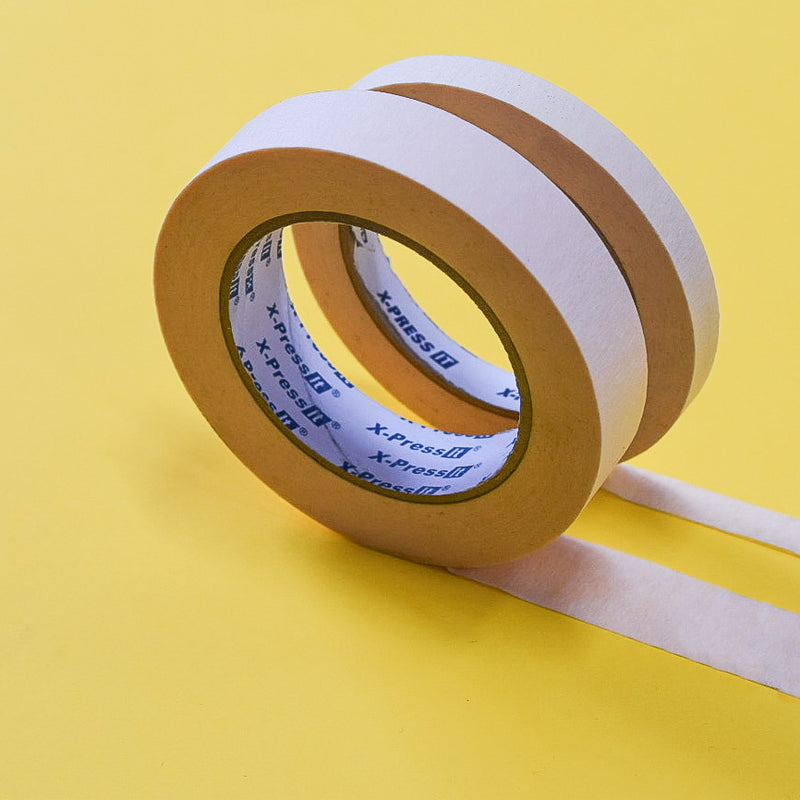 Pair of cream masking tape rolls with printed X-Press It cores on a yellow background, strips unrolled
