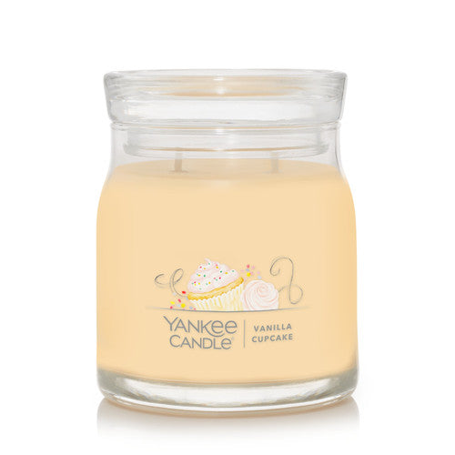 Yankee Candle Signature Medium Jar Vanilla Cupcake on a desk with warm ambient lighting