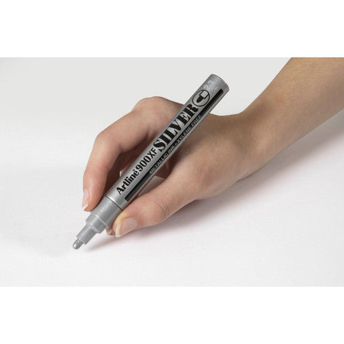 Artline 900 silver metallic marker writing on black surface showing full opacity and reflective finish