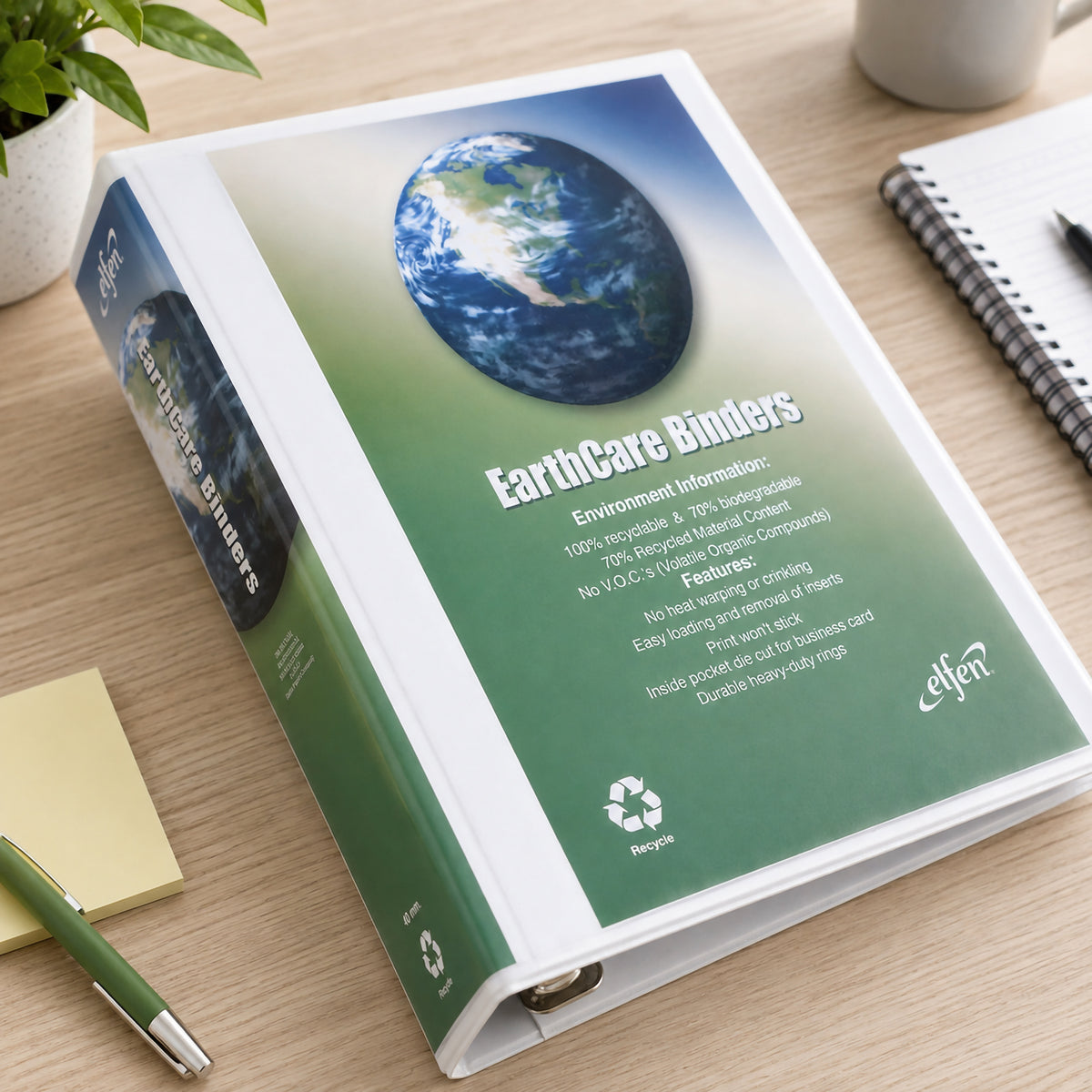 Top view of the Earthcare A4 40mm 4D Ring Insert Binder resting on a timber office desk beside a notebook, pen, sticky notes and indoor plant. The customised cover insert and clear protective sleeve demonstrate the binder's presentation quality and easy document identification.