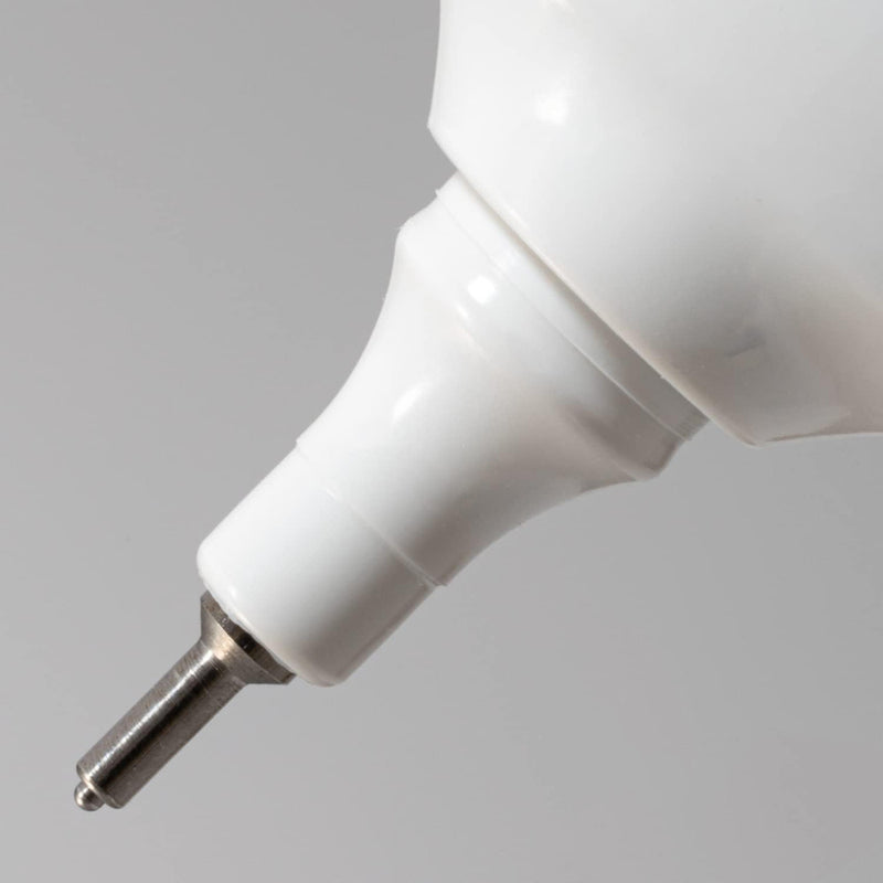 Close-up of the white nozzle and metal tip of a Pentel fine point correction pen against a grey background