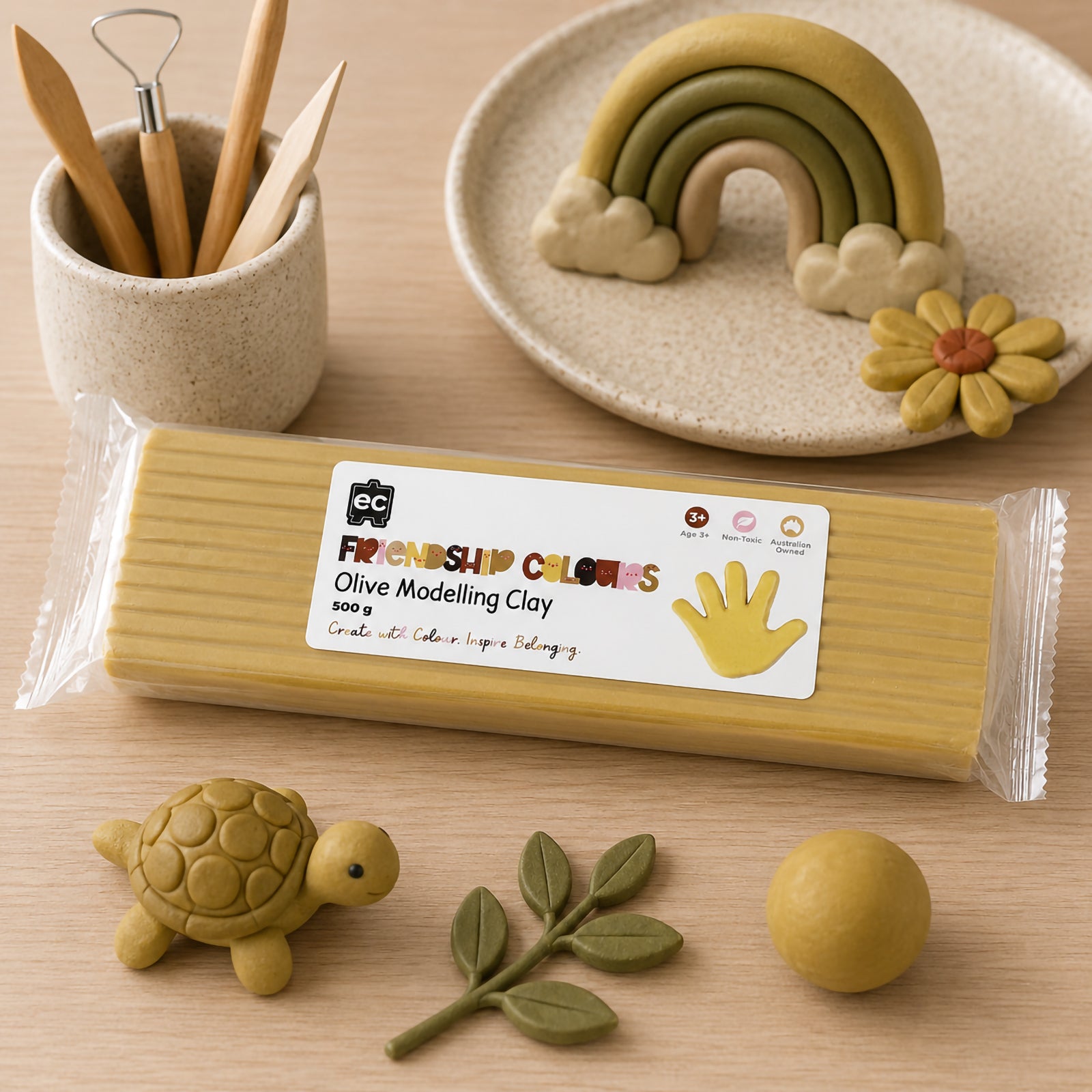 Educational Colours Friendship Colours Olive Modelling Clay 500g displayed with handcrafted clay creations including a turtle, leafy branch and layered rainbow sculpture. The olive toned clay demonstrates its smooth texture, flexibility and suitability for creative classroom projects, sensory activities and inclusive learning experiences.