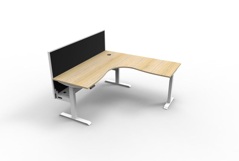 Rapidline Boost Plus corner workstation with Natural Oak top on a white satin sit-stand frame, black fabric screen along the back edge and cable tray underneath