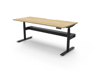 Rapidline Halo Plus electric height adjustable single sided workstation on 70mm diameter round columns, E0 rated Natural Oak top with a black satin powdercoated frame, fitted ducted cable tray. Rapidline range image supplied for model H+1PCT1875 NO/BL.