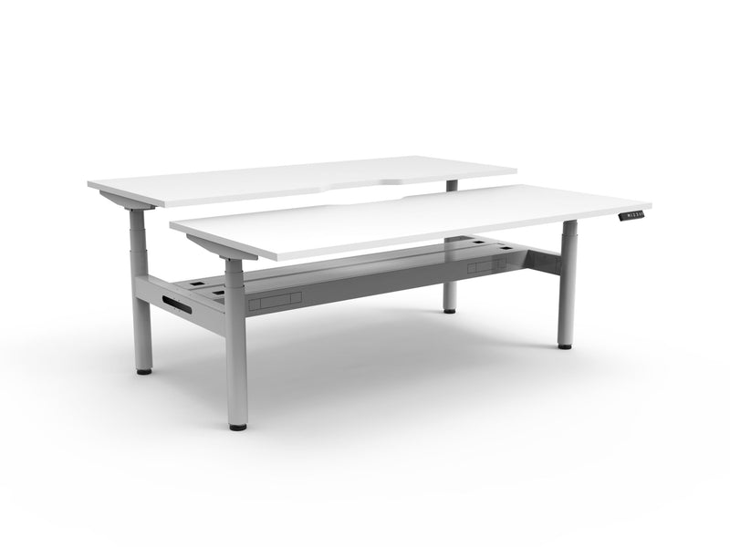 Rapidline Halo Plus electric height adjustable back to back workstation on 70mm diameter round columns, E0 rated Natural White top with a white satin powdercoated frame, fitted ducted cable tray. Rapidline range image supplied for model H+2PCT1275 NW/WS.