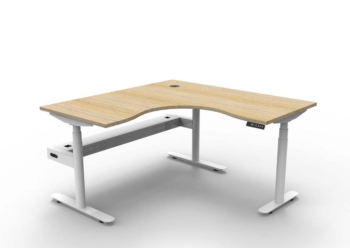 Rapidline Halo Plus electric height adjustable corner workstation on 70mm diameter round columns, E0 rated Natural Oak top with a white satin powdercoated frame, fitted ducted cable tray. Supplied product image for model H+CNRCT1P1515 NO/WS.