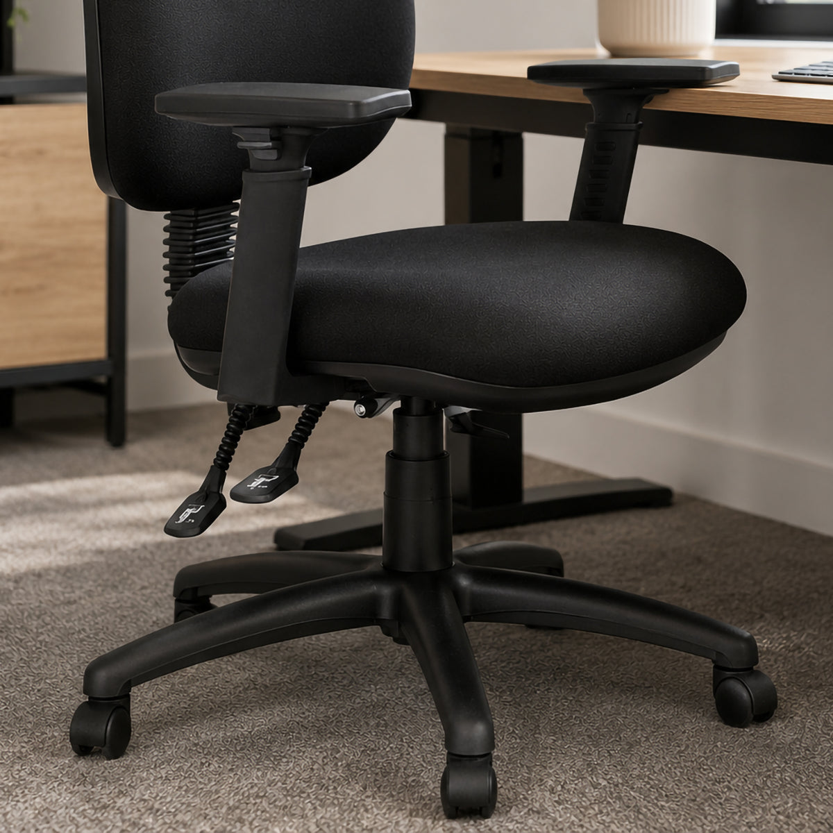 Close view of a Mondo Java office chair fitted with black adjustable arms, highlighting the arm pads, adjustment mechanisms, upholstered seat, chair controls and five star mobile base.