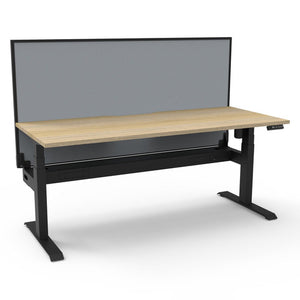 Rapidline Boost Light single sided electric sit-stand desk with a natural oak top on a black frame, a grey fabric screen across the back and a cable tray running under the top, with the controller at the front right edge