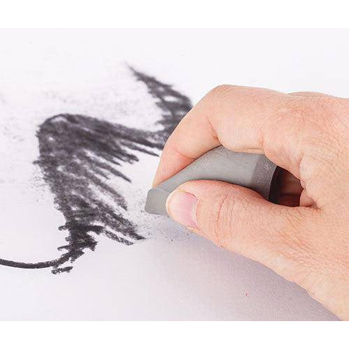 Kneadable eraser lifting charcoal marks from paper